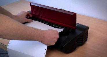 Mãos colocando papel contínuo em uma das impressoras braille abordadas no manaul