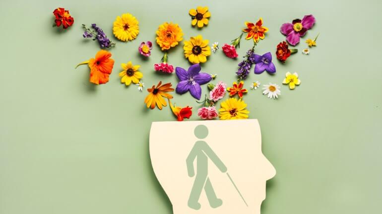Desenho de cabeça aberta saindo flores e ao centro ícone de pessoa com deficiência visual.